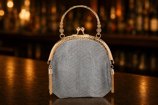 Gold-framed silver mesh evening bag on a bar counter with warm evening bokeh